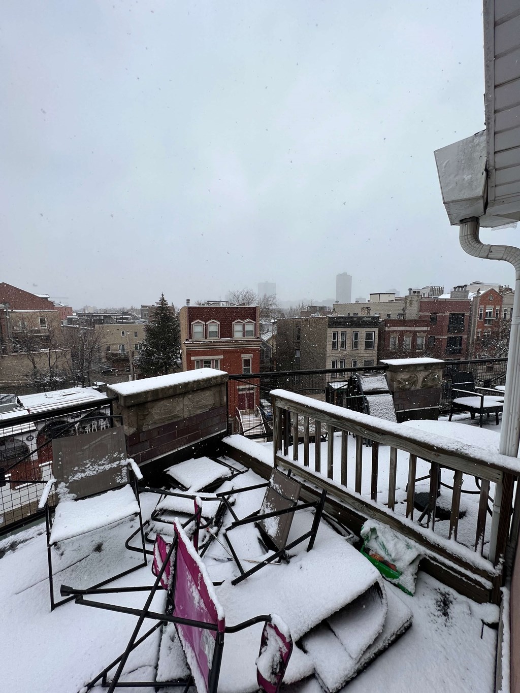 a balcony covered in snow with a city in the background
