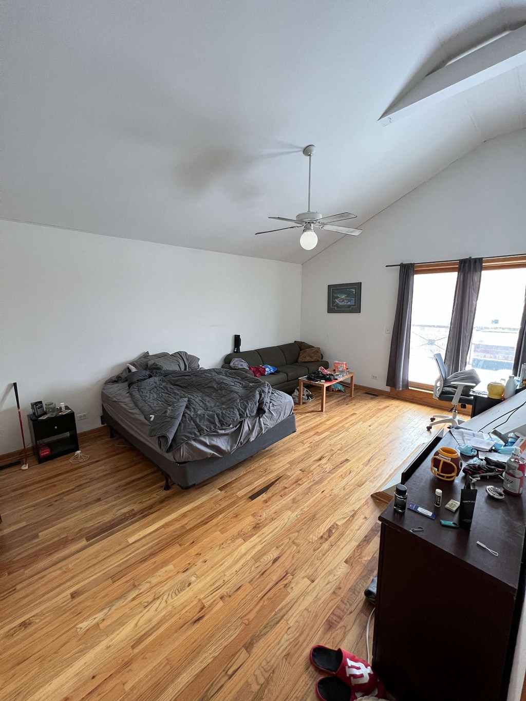 a living room with a bed and a ceiling fan