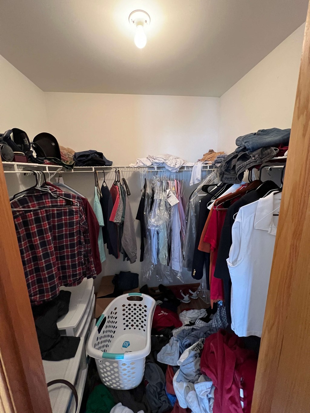 a closet filled with clothes and a pile of clothes in it