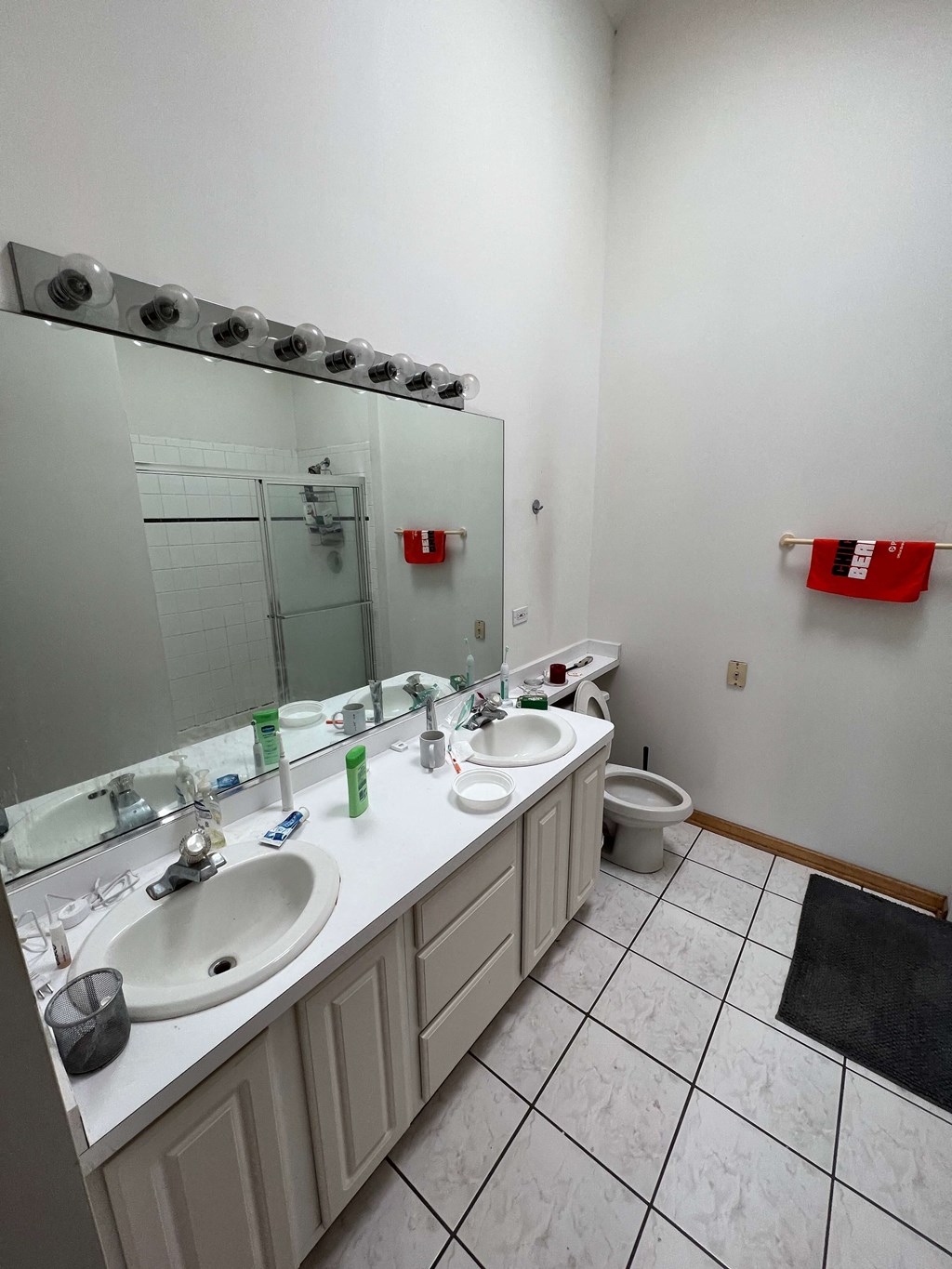 a bathroom with two sinks and a toilet and a mirror