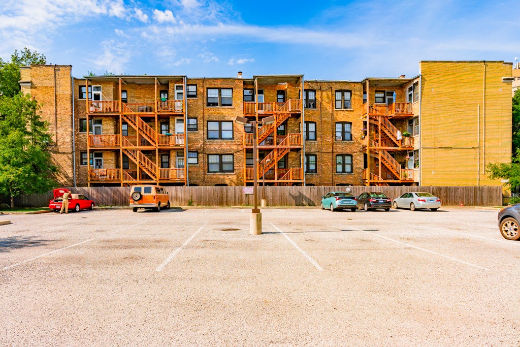 an empty parking lot in front of an apartment building