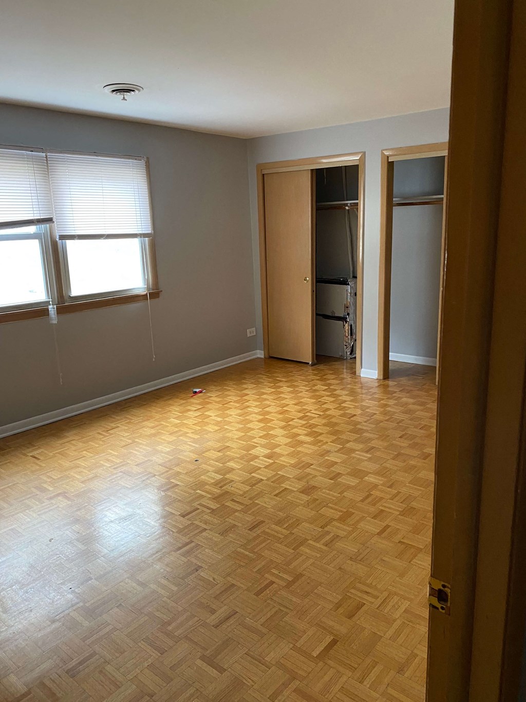 an empty living room with wood flooring and a closet