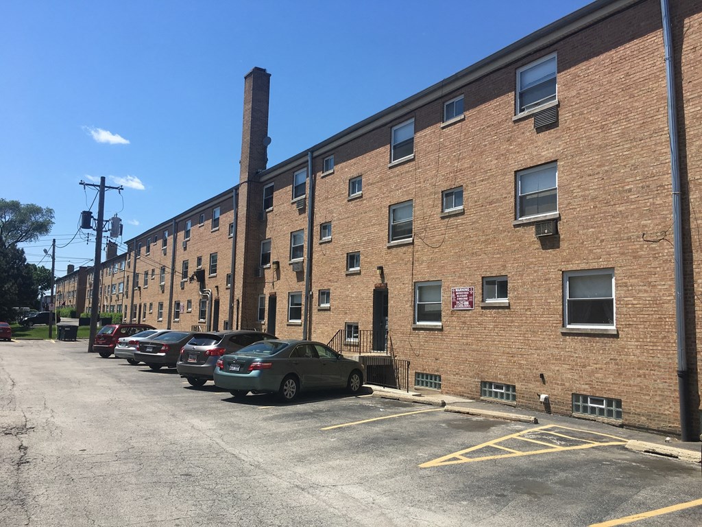 a large brick building with cars parked in front of it