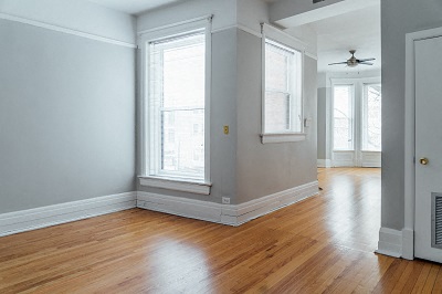 an empty living room with wood floors and windows