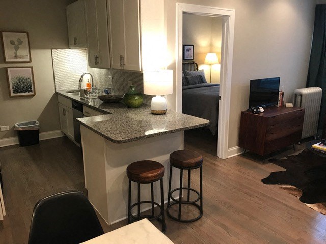 a small kitchen with a counter top and stools