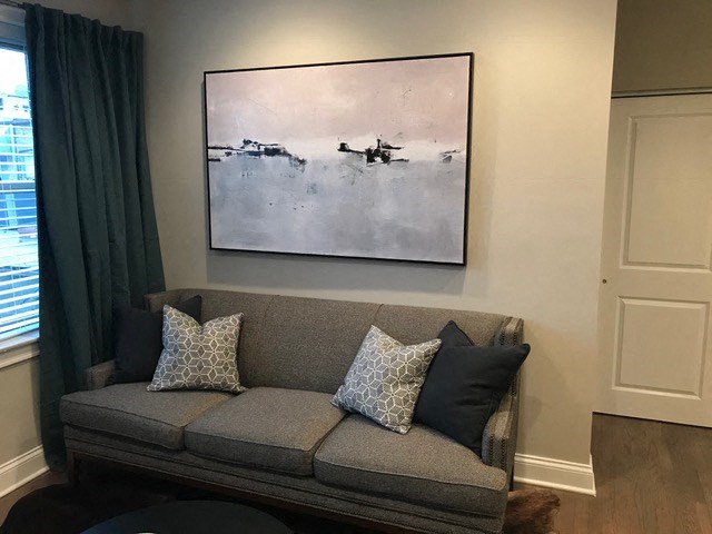 a living room with a couch and a painting on the wall
