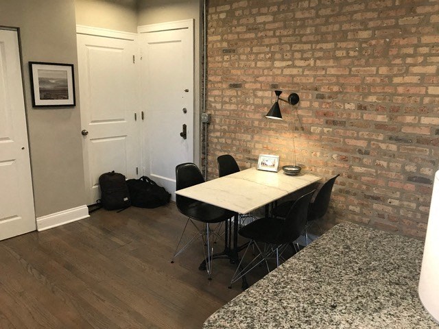 a dining room with a table and chairs and a brick wall