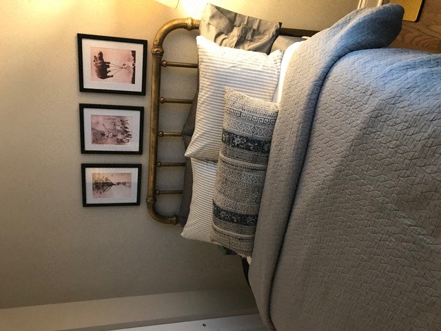 a bed with pillows and pictures on the wall