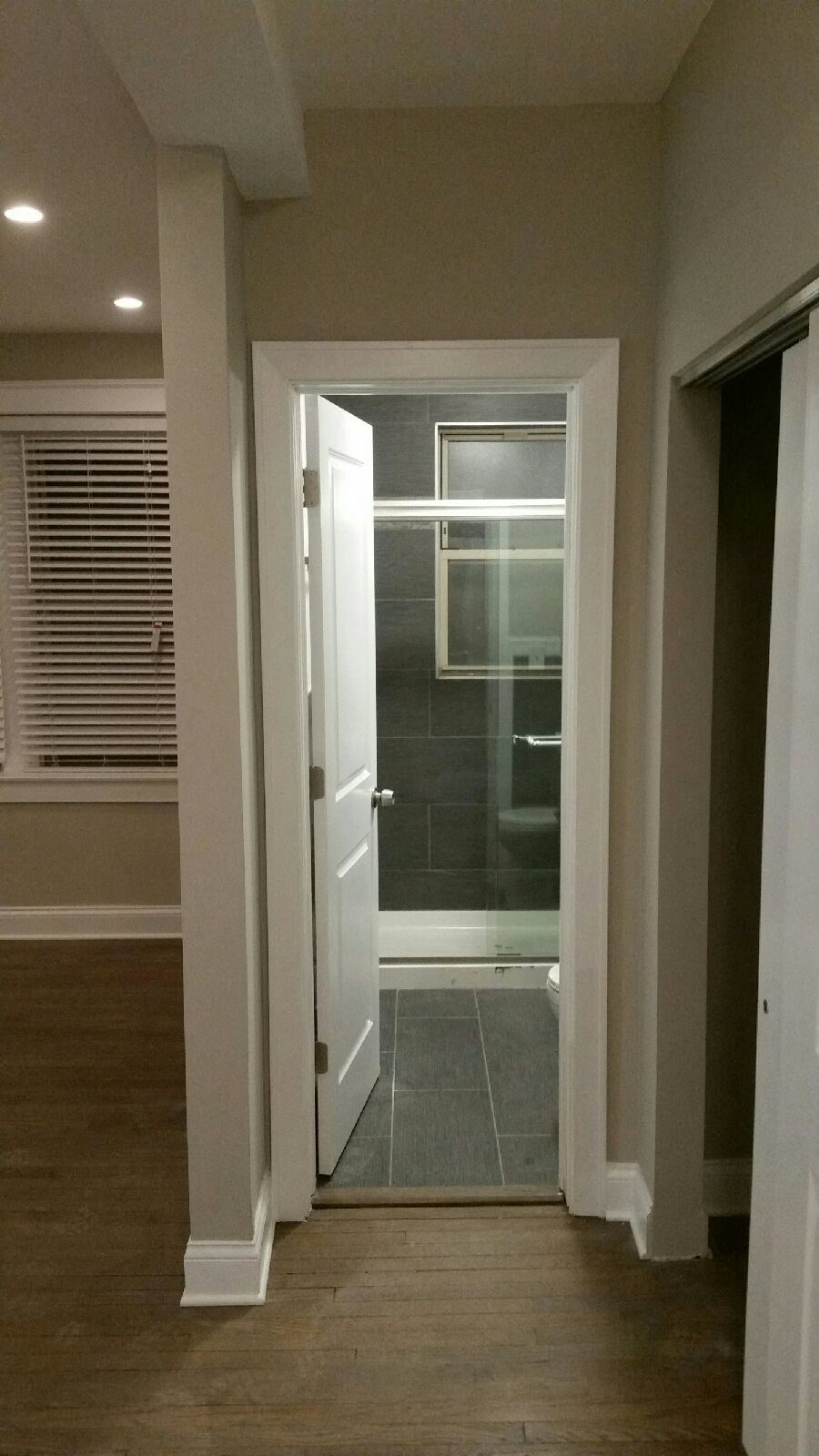 a view of a bathroom from a hallway with a glass shower door