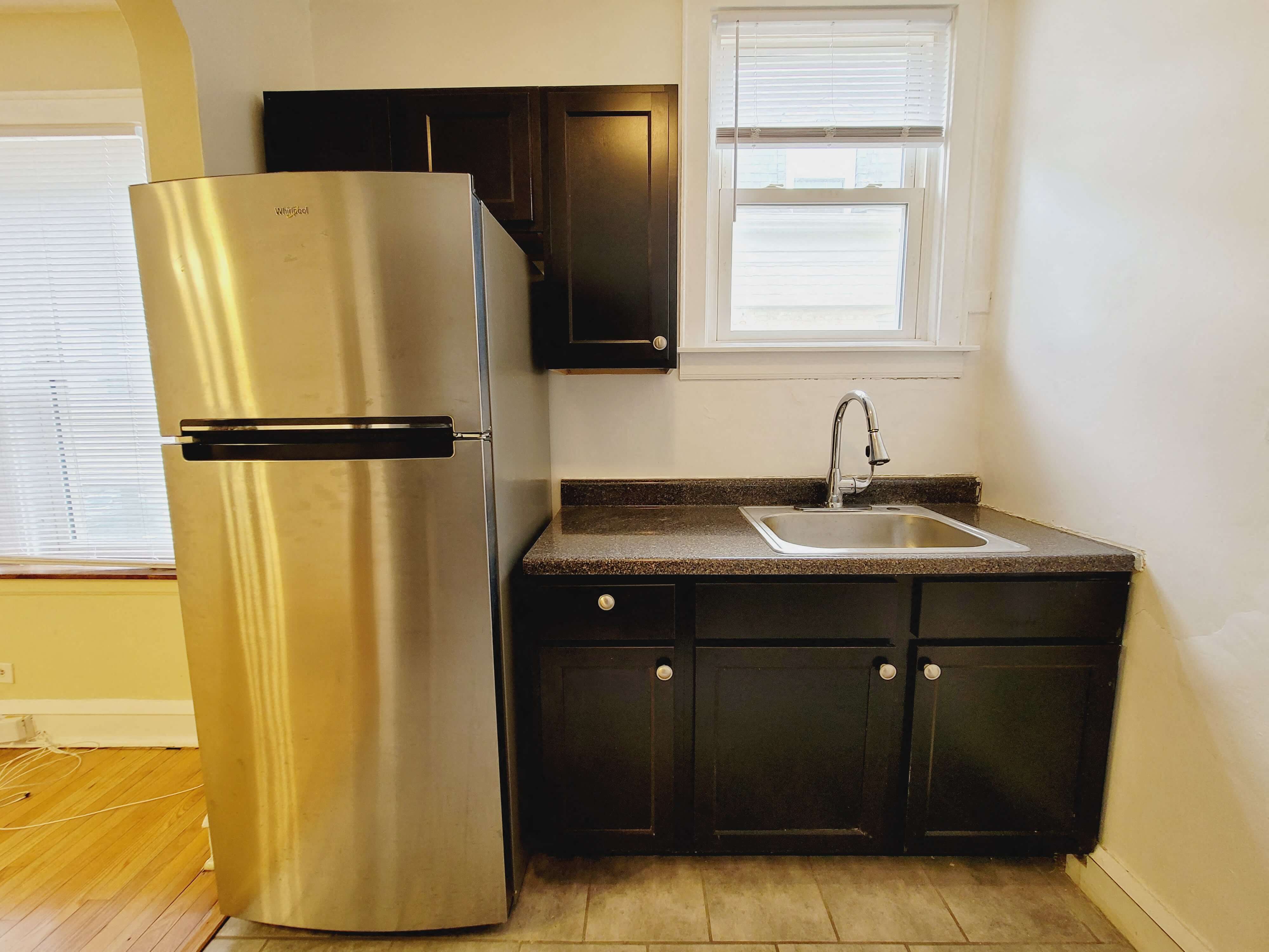 a small kitchen with a refrigerator and a sink
