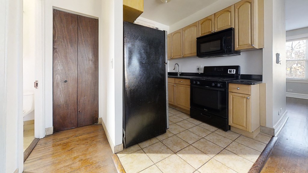 a kitchen with black appliances and wooden cabinets