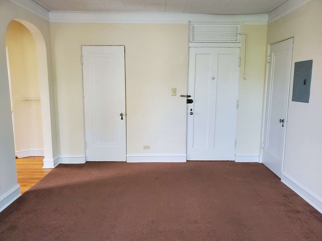 an empty room with white doors and a carpet