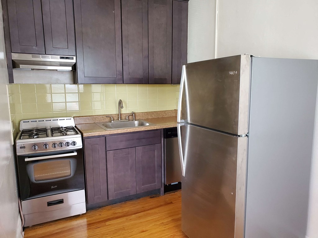 an empty kitchen with a stainless steel refrigerator and stove