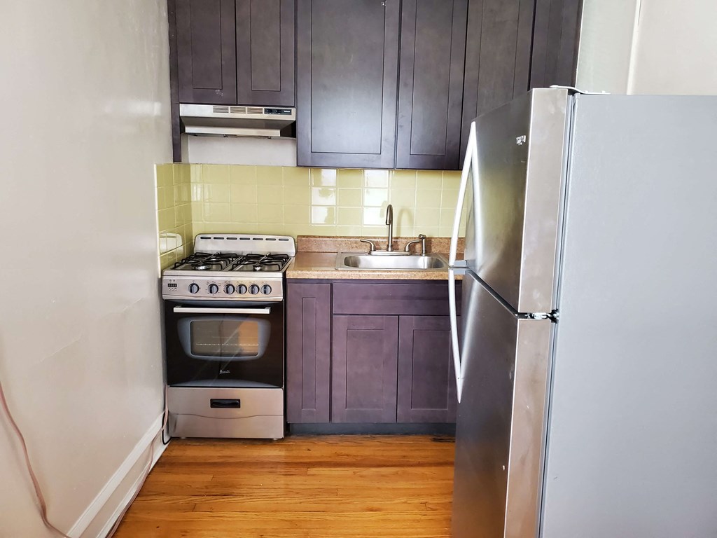 a small kitchen with a stove and a refrigerator