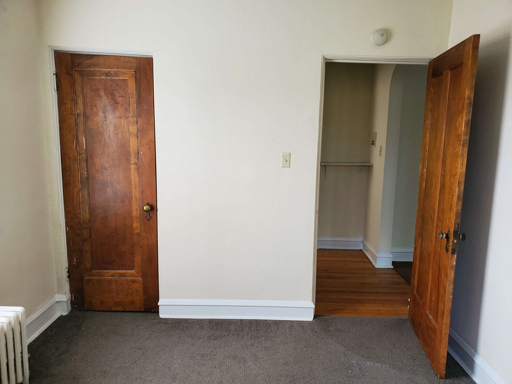 a room with a door open and a hallway to a closet