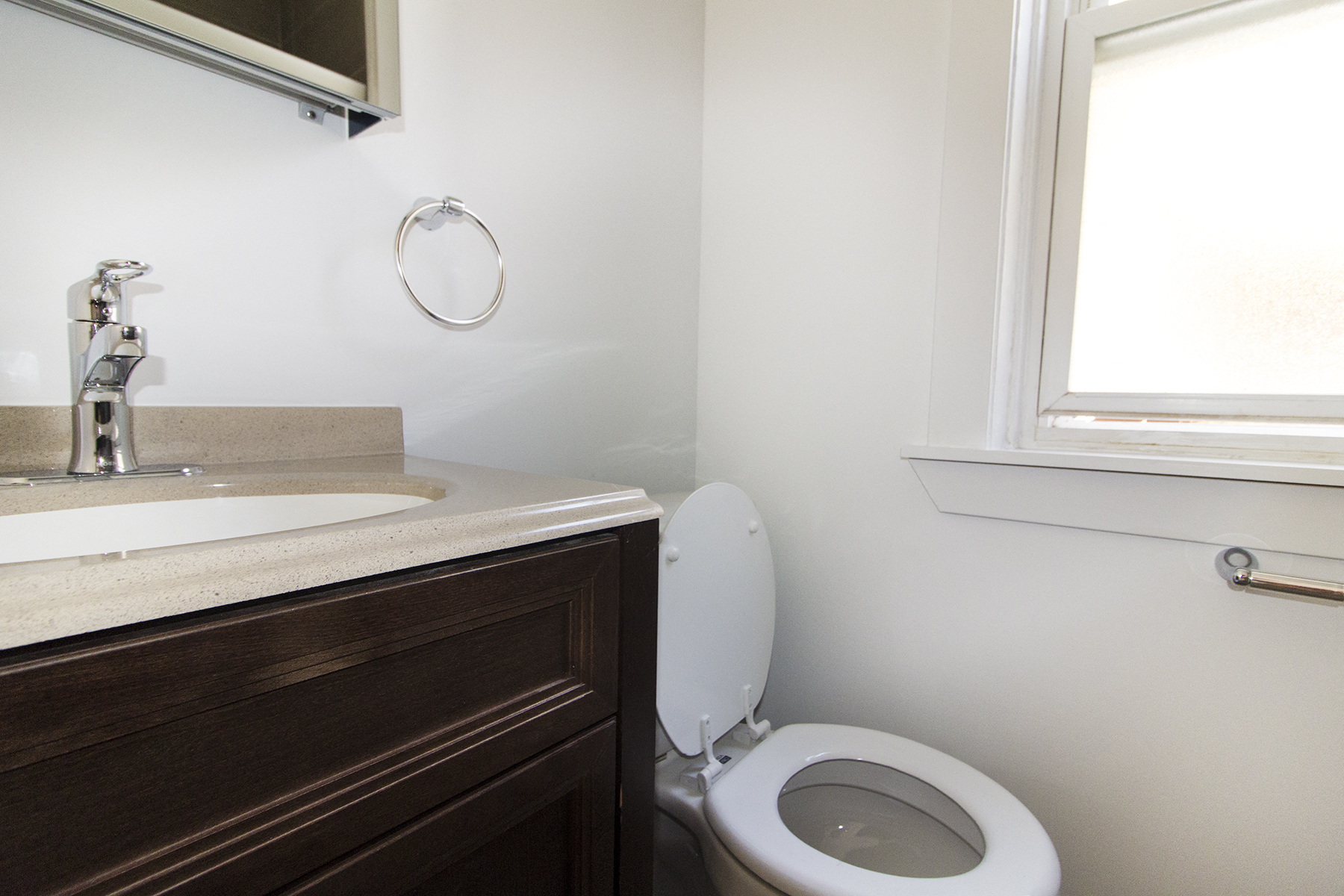a bathroom with a toilet and a sink and a window