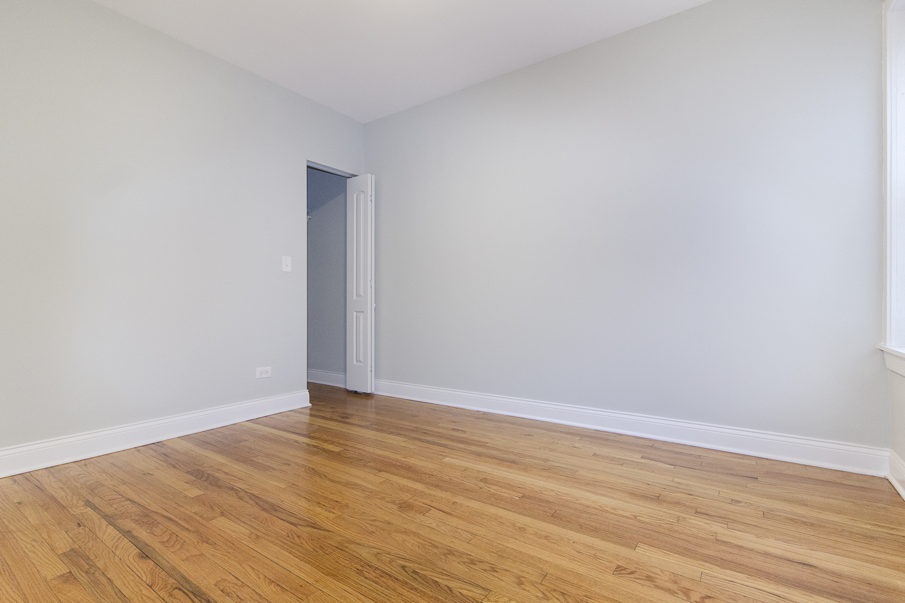 an empty room with wood floors and white walls