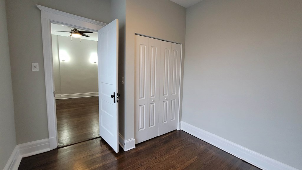 a bedroom with a closet and a door open to a hallway