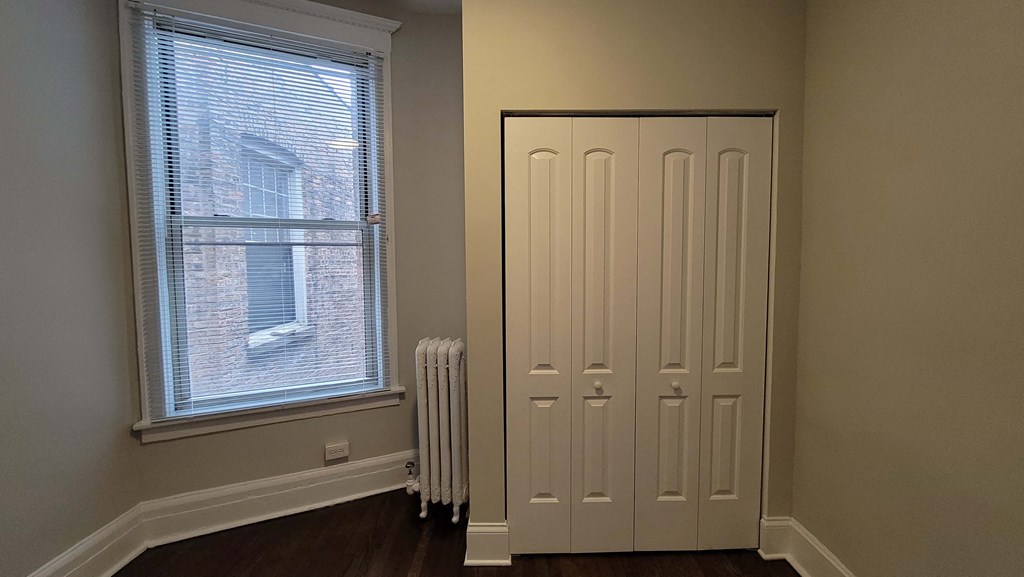 a door in a room with a radiator and a window