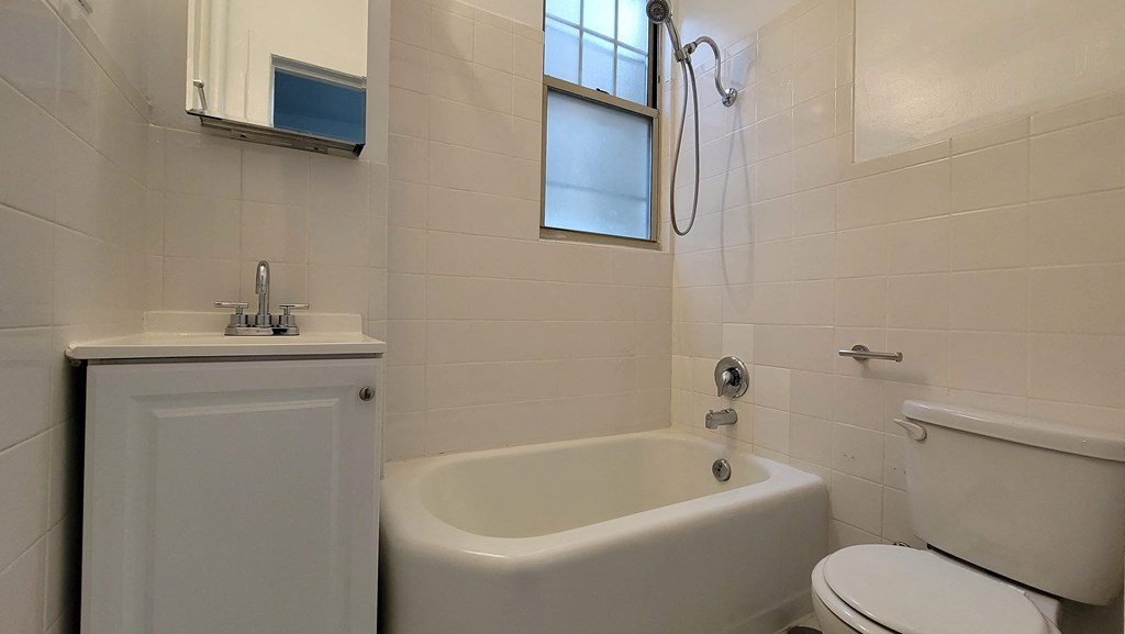 a bathroom with a toilet sink and tub and a window