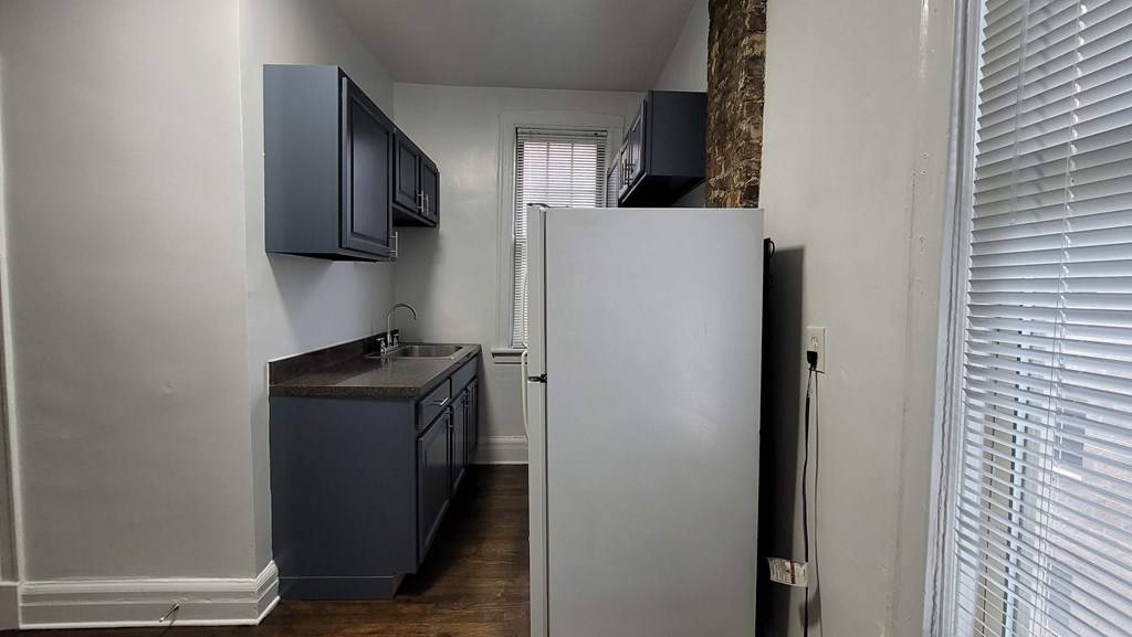 a small kitchen with a refrigerator and a sink