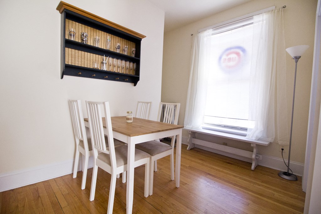 a dining room with a table and chairs and a window