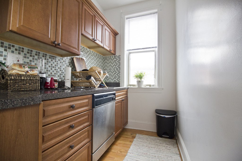 a kitchen with wooden cabinets and a stainless steel dishwasher