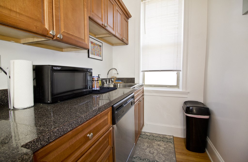 a kitchen with a counter top and a sink and a microwave