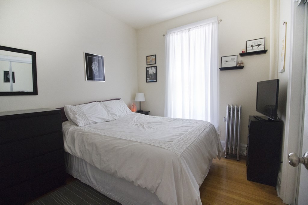 a bedroom with a bed and a television