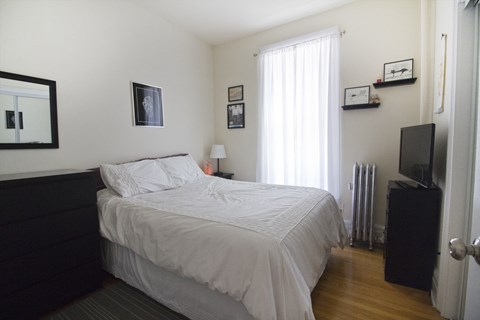 a bedroom with a bed and a television