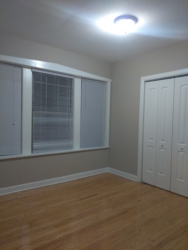 an empty room with a window and a closet