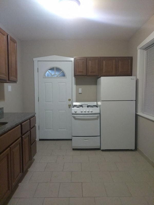 a kitchen with white appliances and wooden cabinets