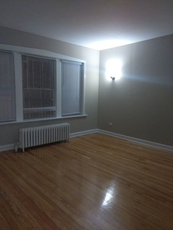 the living room of a house with a wood floor and a window
