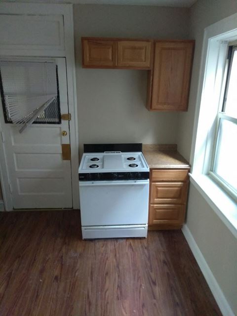 an empty kitchen with a stove and a door