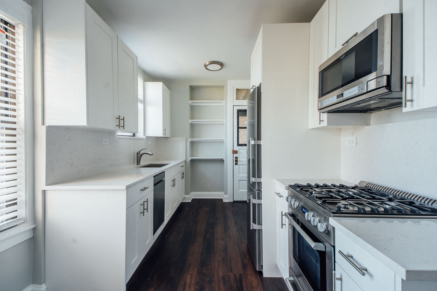 a kitchen with white cabinets and a stove and a microwave