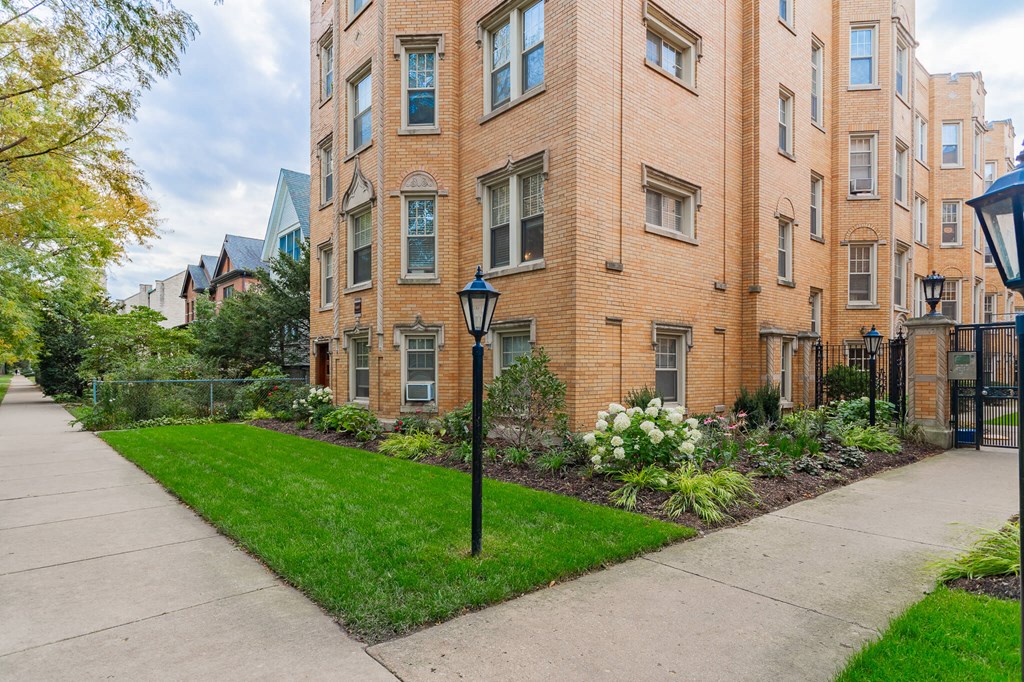 a sidewalk in front of a brick apartment building