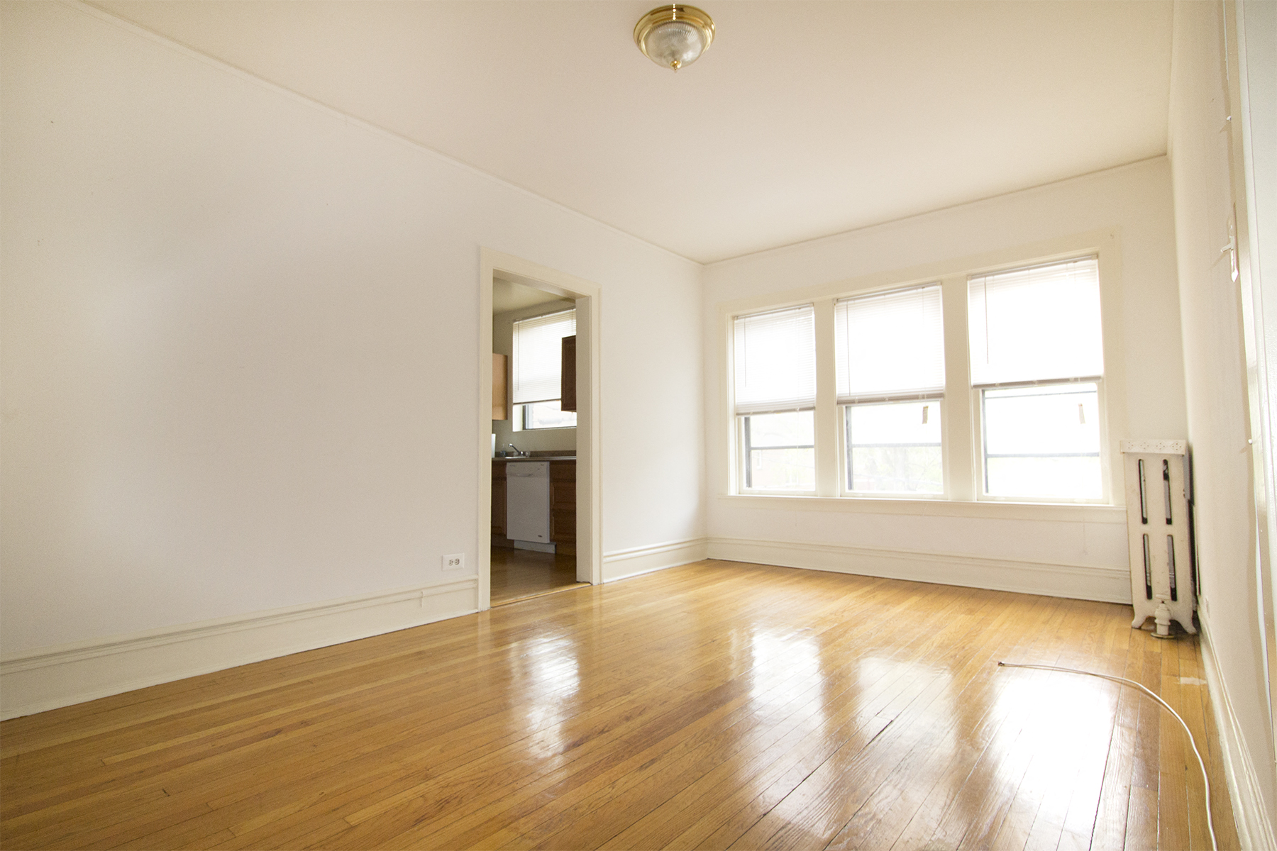 an empty living room with white walls and wood floors
