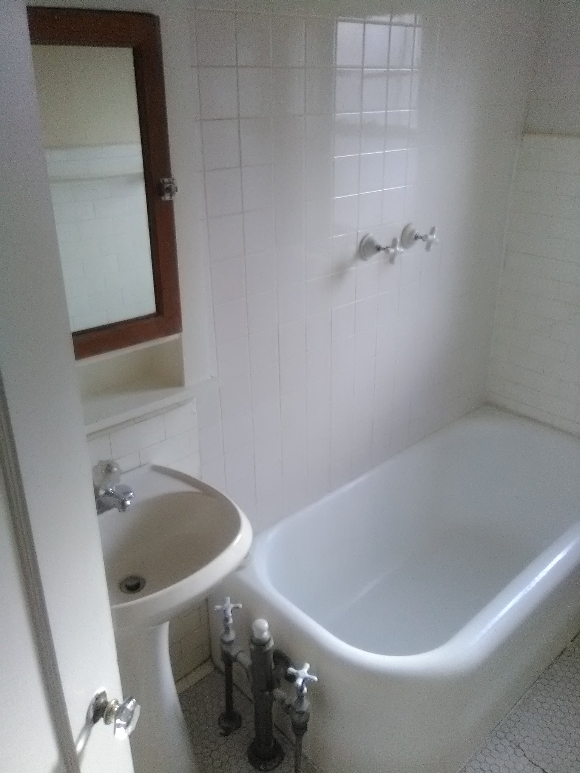 a white bathroom with a sink and a tub