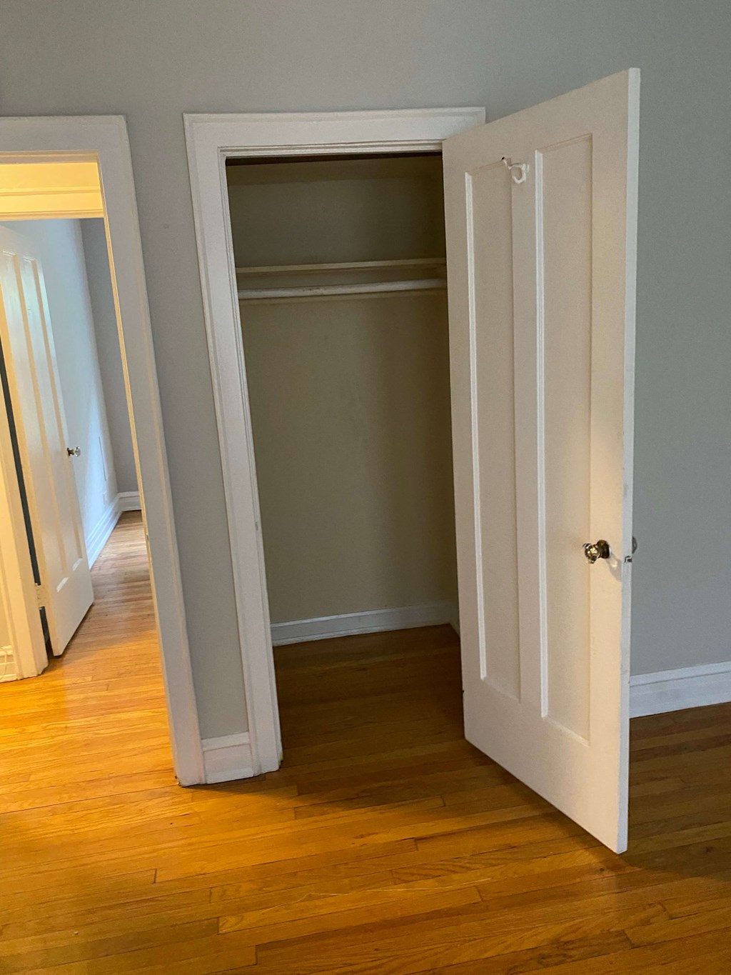 an open closet door in a room with wood floors