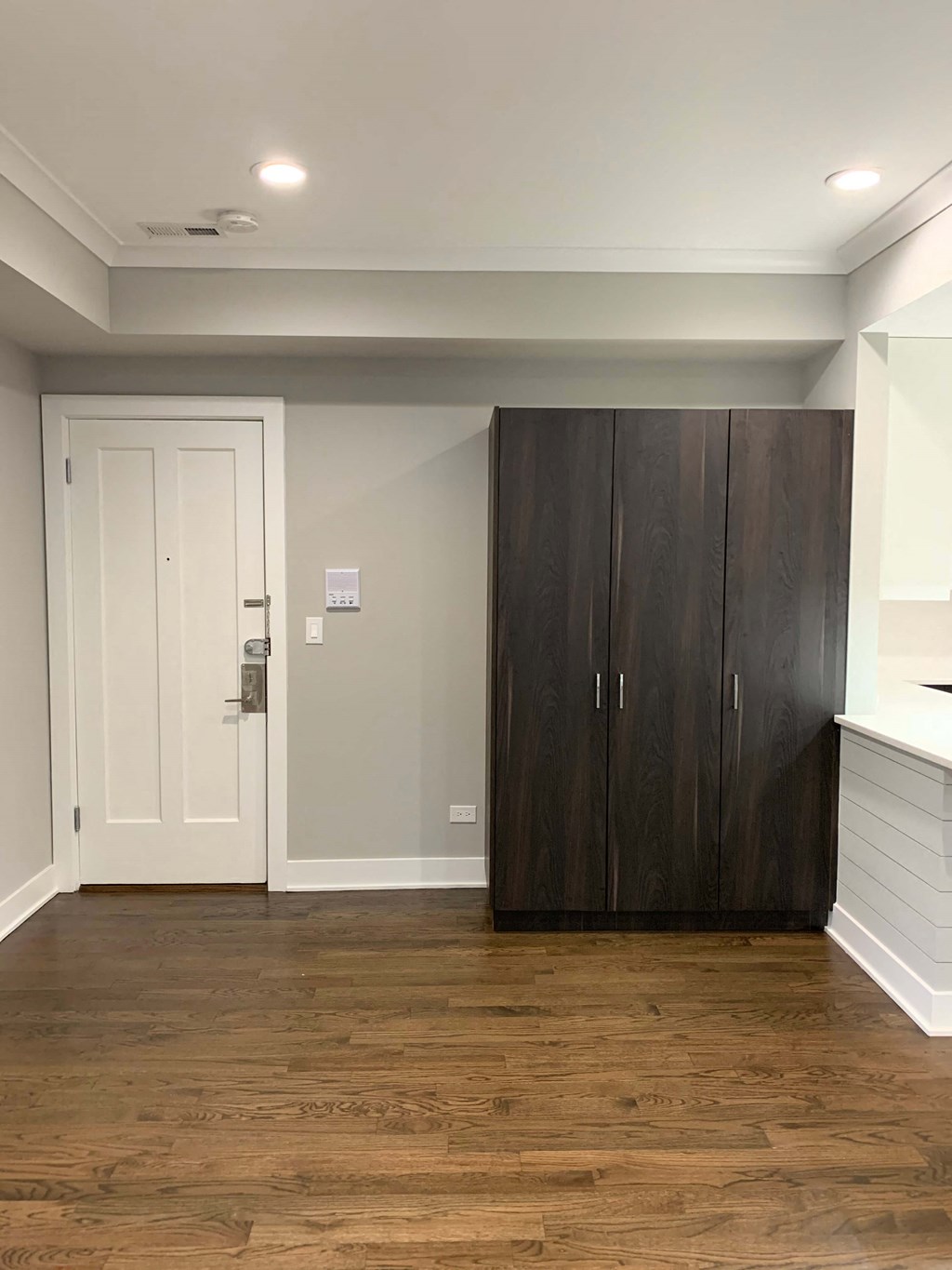 a living room with a wooden floor and a large wooden closet
