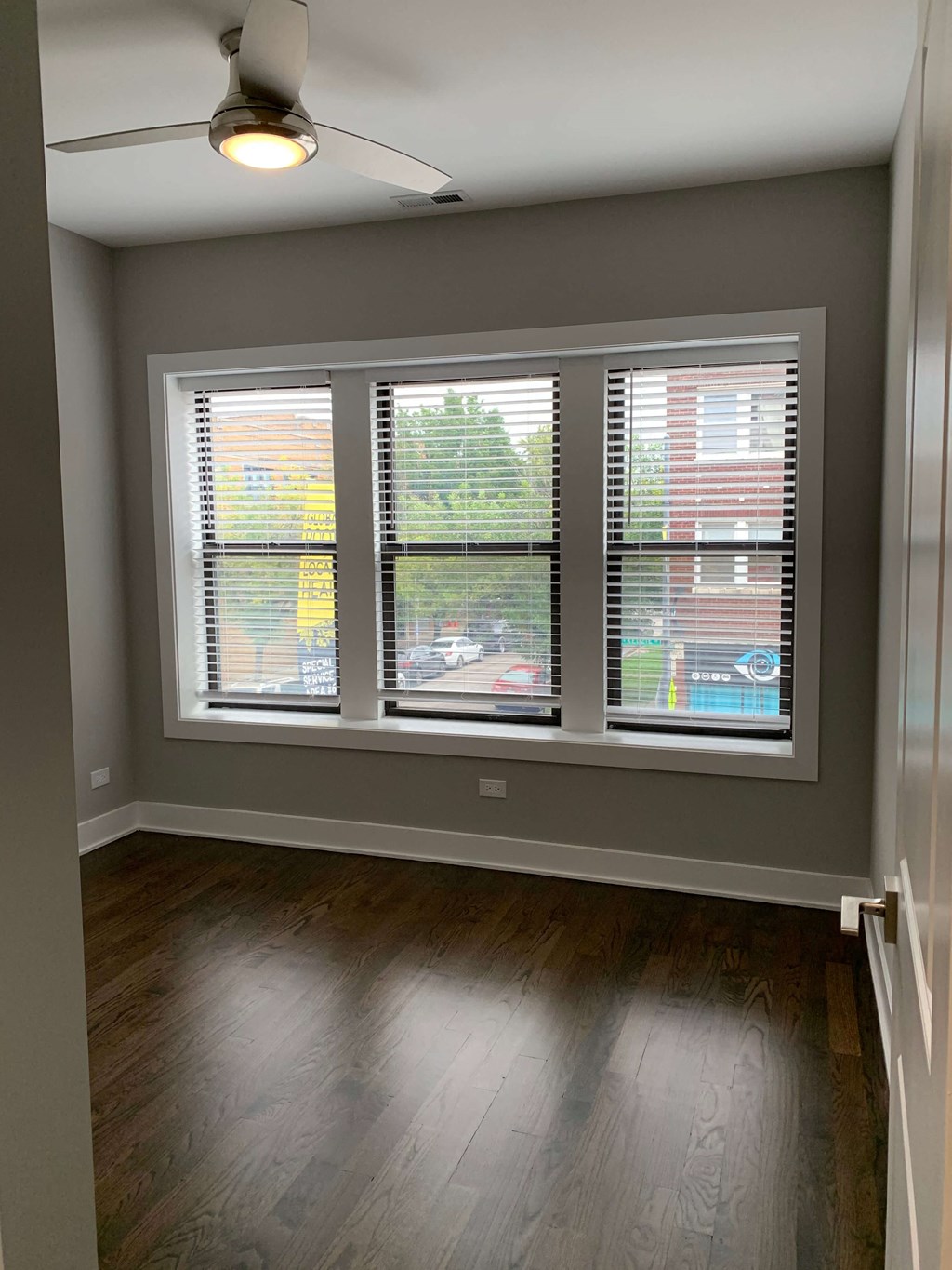 a view of a living room with windows and wood floors