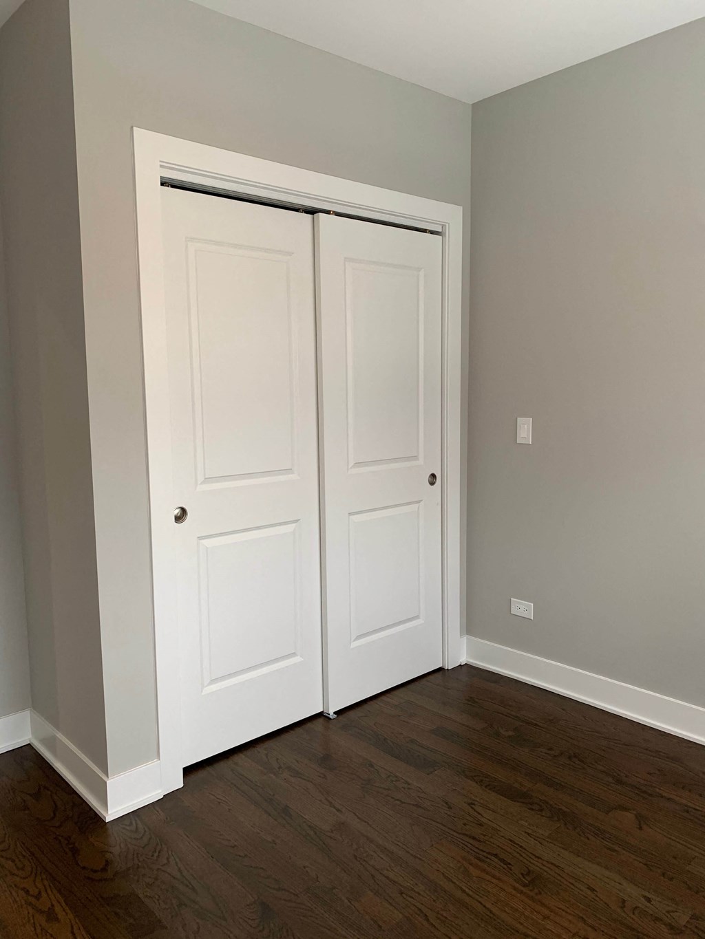a room with two closet doors and a wooden floor