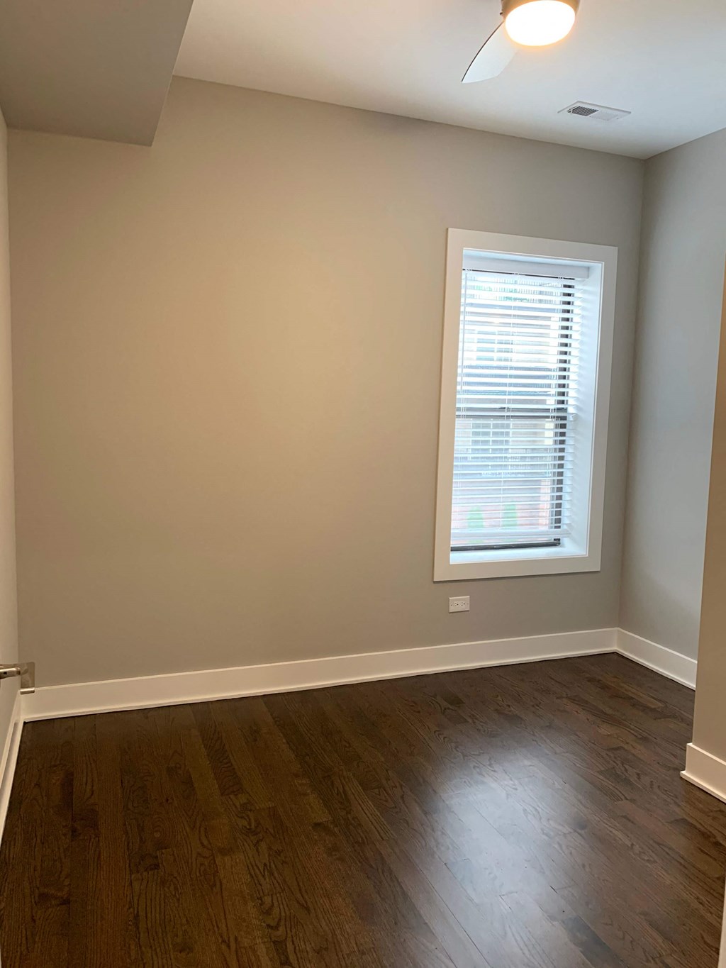 a living room with a window and wooden floors