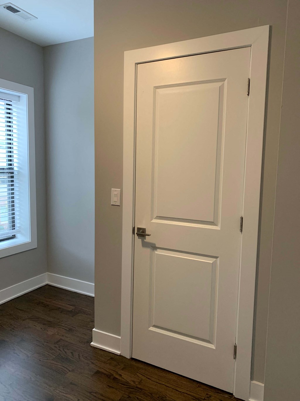 a white door in a room with a window