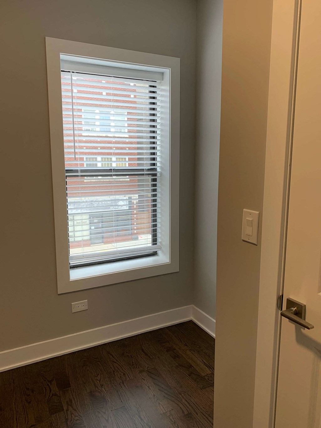 a window in a room with a wooden floor and a door