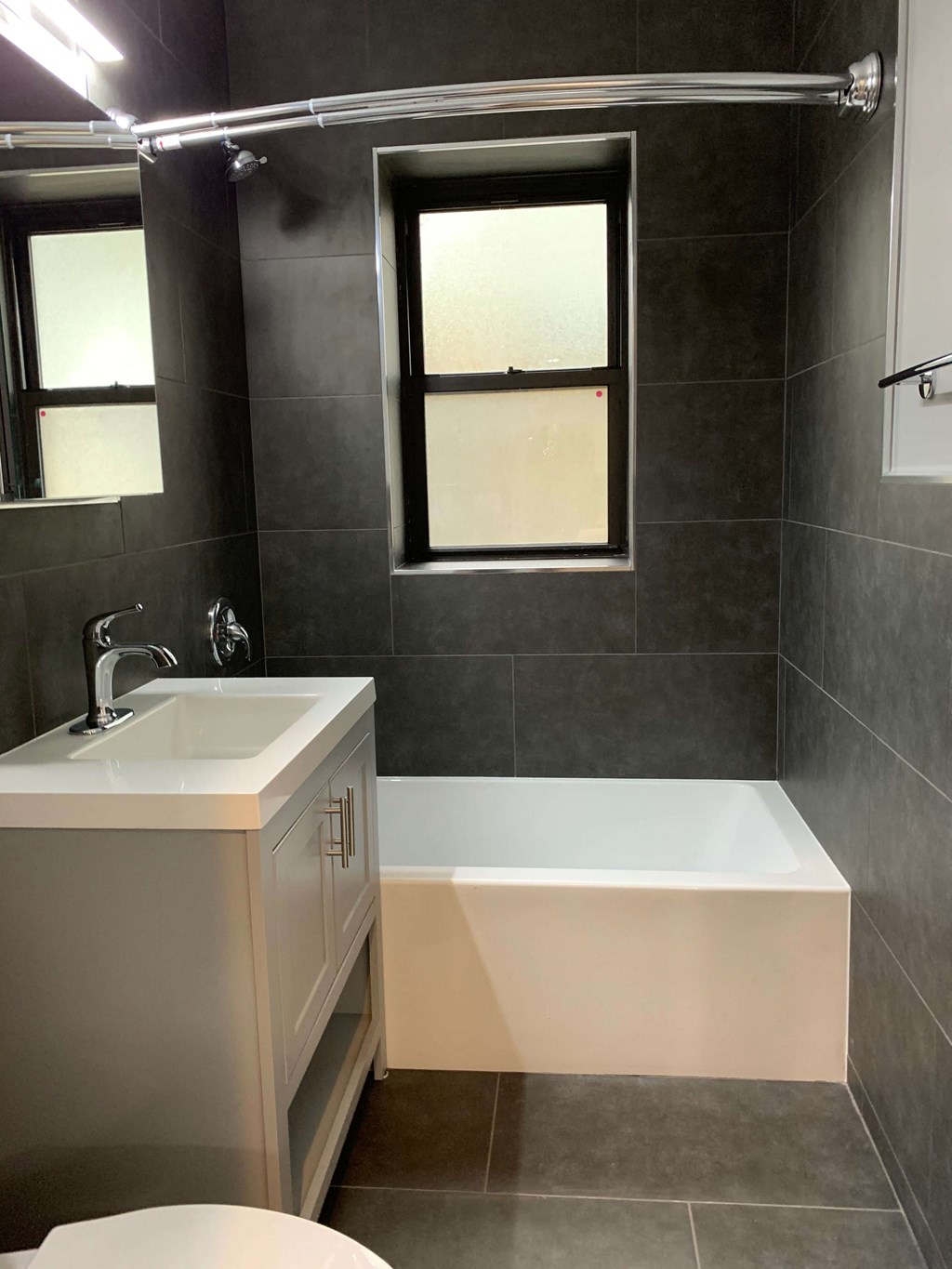 a bathroom with a sink and a bath tub and a window