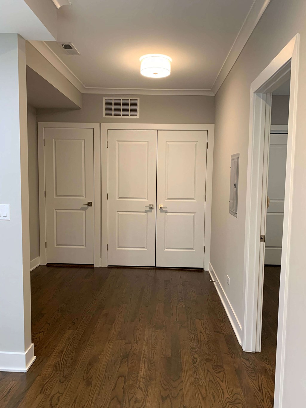 a hallway with white doors and a wood floor