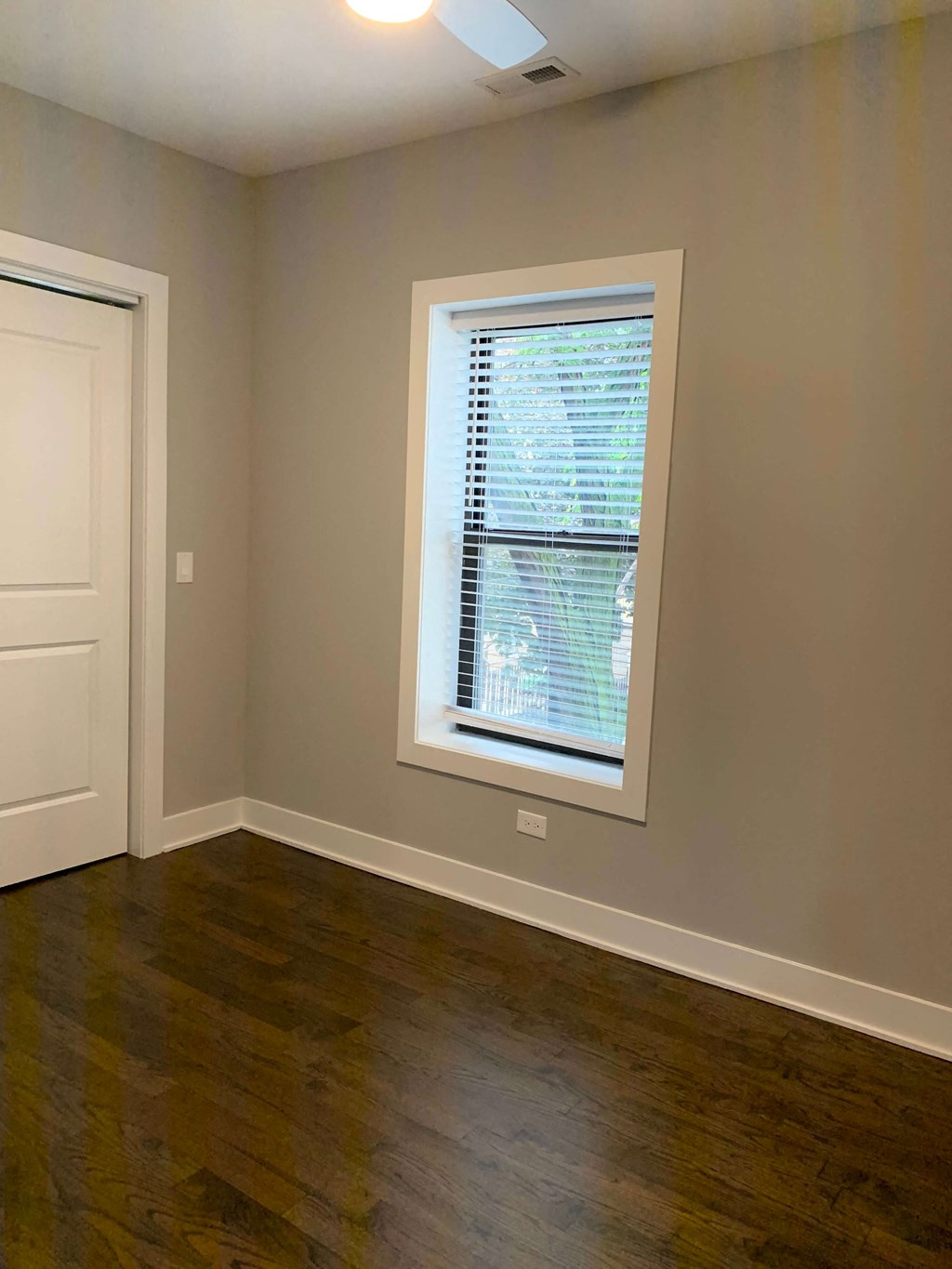 a living room with a window and wooden floors