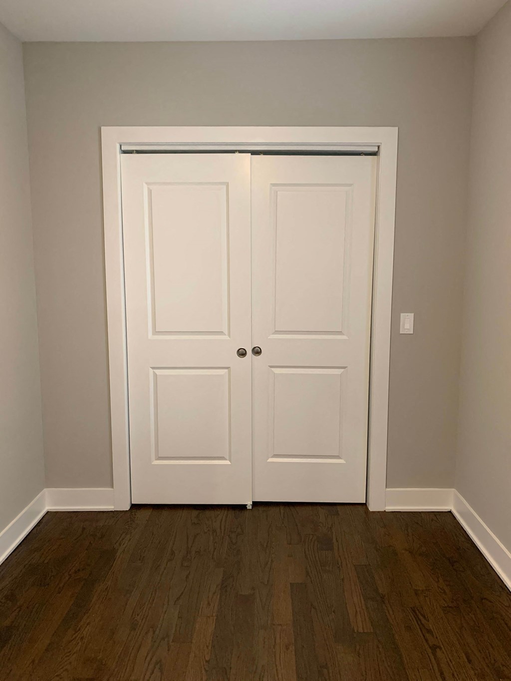 a pair of closet doors in a room with wooden floors