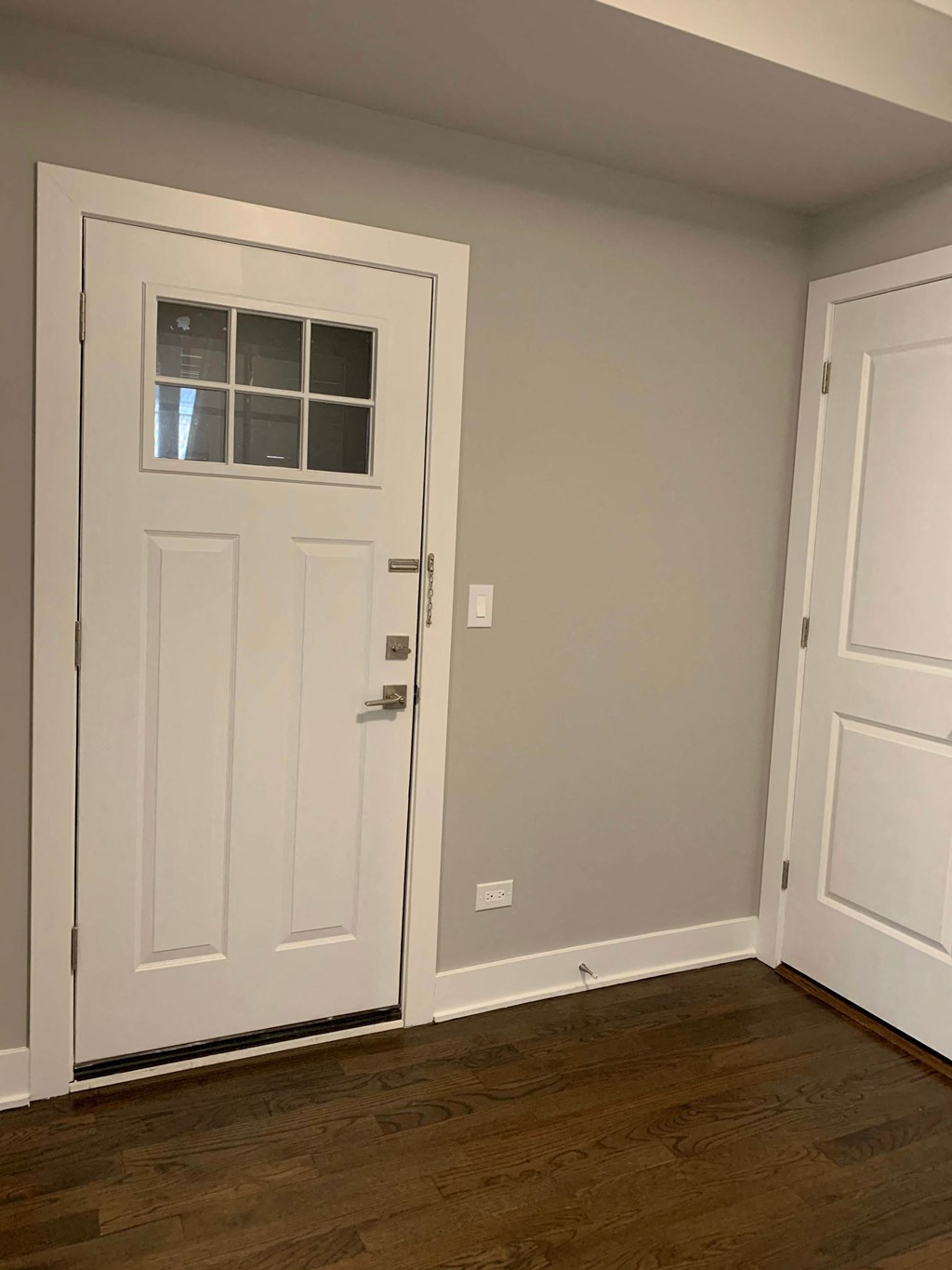 a white door in a room with a wooden floor